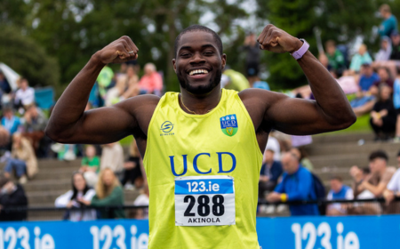 Bori Akinola smiling and flexing his arms after a race.